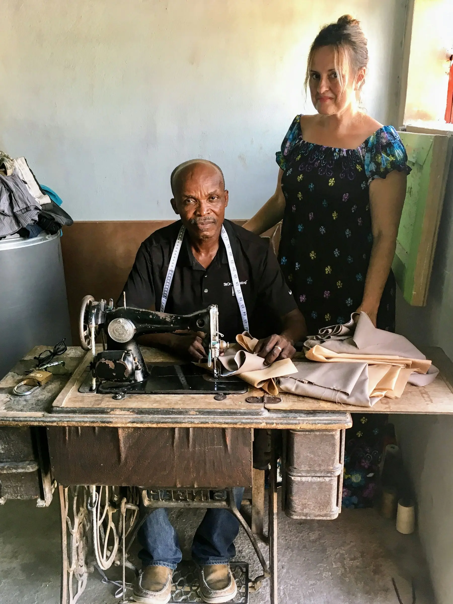 A tailor at work at his sewing machine in his workshop